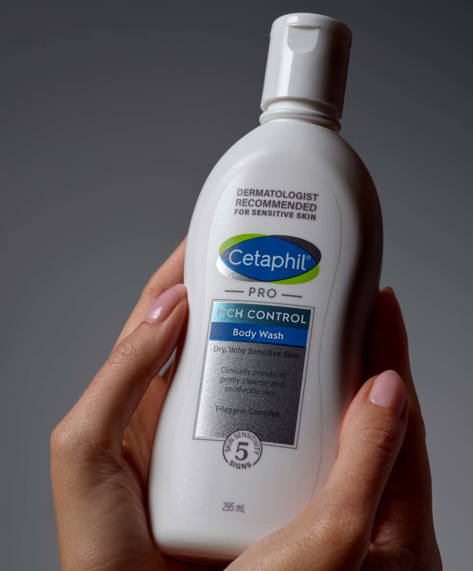 Trzymane w dłoniach opakowanie emulsji do mycia Cetaphil Itch Control.