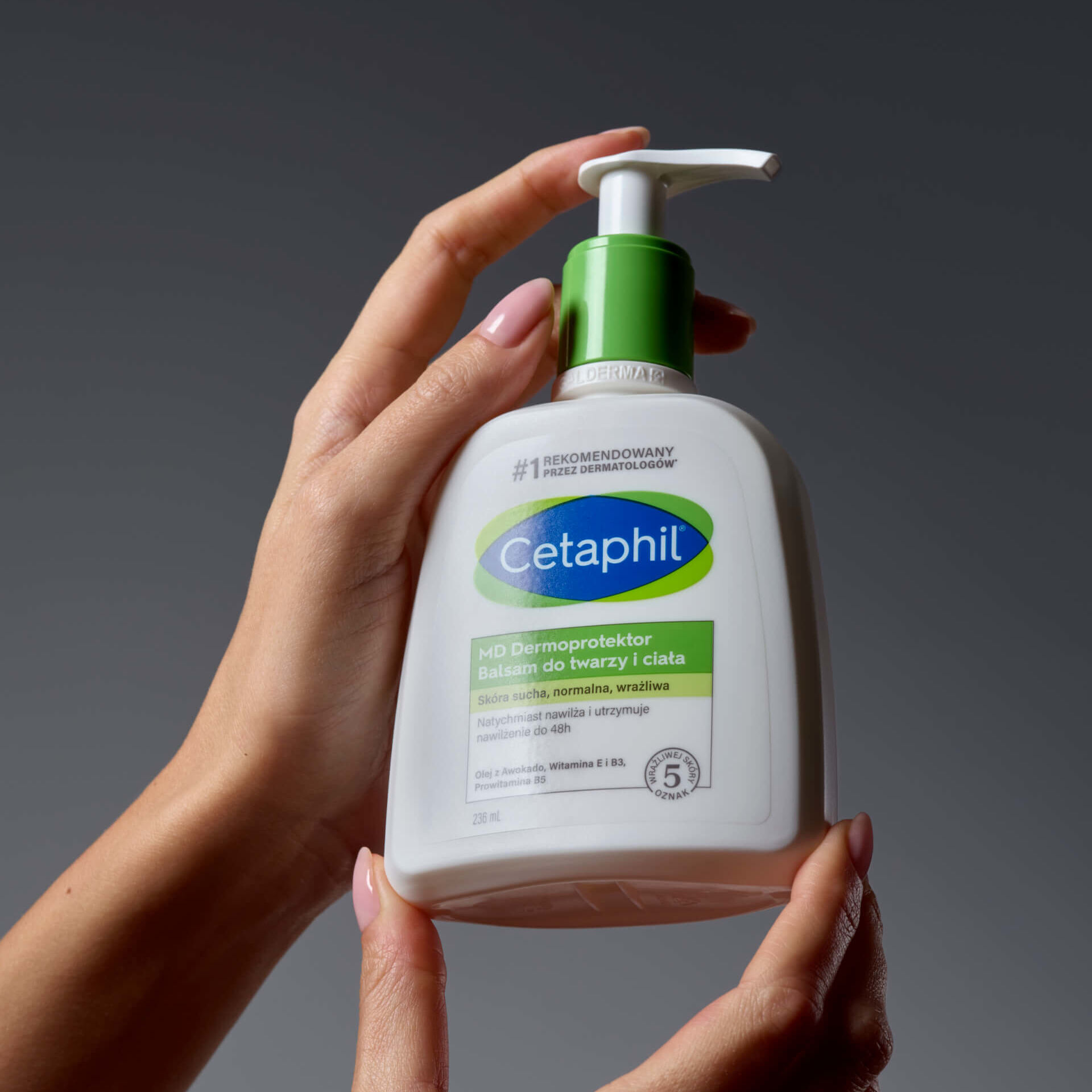 Balsam do twarzy i ciała Cetaphil trzymany w dłoniach.