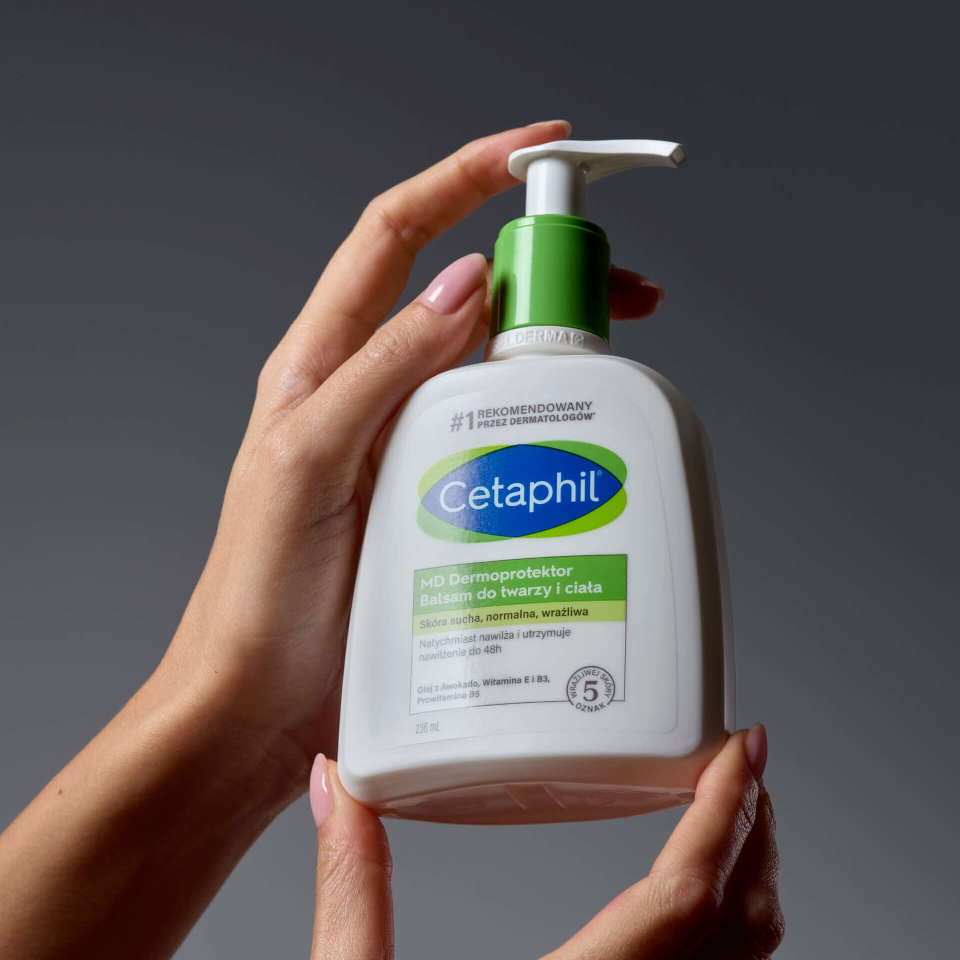 Balsam do twarzy i ciała Cetaphil trzymany w dłoniach.